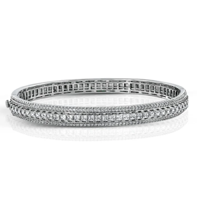 Women’s classic charm bracelets-This 18k bangle provides extra sparkle with .93 ctw of round white diamonds in rows flanking 3.19 ctw of princess cut white diamonds.